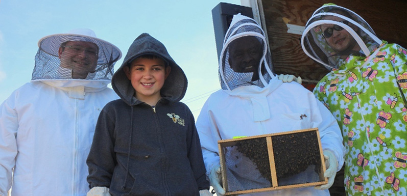 GloryBee employees holding bee box