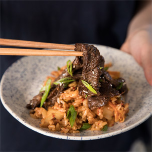 Caramelized Korean Beef With Kimchi Fried Rice with chopsticks