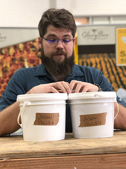 Man looking at pails of pollen